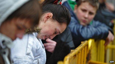 People wait for news at the scene where the Maxima supermarket roof collapsed in Riga on November 22, 2013.