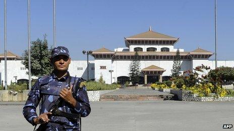 A police officer stands guard in front of the parliament building in Kathmandu (19 November 2013)