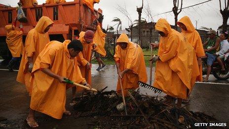 Workers clear part of the road near Bassey in Eastern Samar, Philippines (22 Nov. 2013)