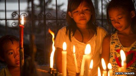 Children gather round candles during a Latin mass ceremony at a local Chapel in Santa Rita township on November 22, 2013 in Eastern Samar, Philippines