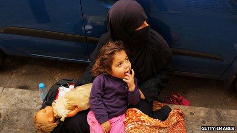 A Syrian woman from the city of Aleppo begs with her daughter Zahra (3) in a wealthy district of Beirut on November 16, 2013