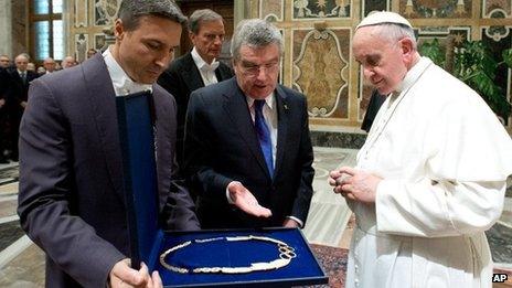 Pope Francis is presented a gift by Thomas Bach, president of the International Olympic Committee, in the Clementine hall at the Vatican on 23 November.