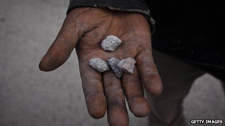 A man holds rocks from eruption of mount Sinabung at Sukanalu village on 24 November 2013 in Karo district, North Sumatra, Indonesia