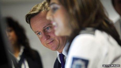 UK Prime Minister David Cameron watches security monitors as he talks to UK border agency officials in their control room during a visit to Heathrow terminal 5 (October 2011)