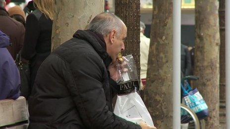 Man eating lunch on bench