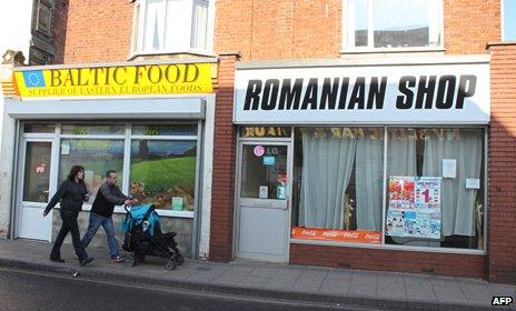 A couple walk past shops catering for eastern Europeans in Boston, in Lincolnshire, eastern Englan