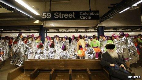 Performers in the 87th Macy's Thanksgiving Day Parade wait for a subway to take them to the start of the parade in New York on 28 November 2013