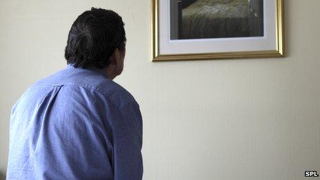 A man staring at a photograph of his dead partner