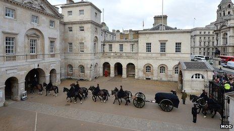 A gun carriage carrying bags of sacred soil is processed through Horse Guards Parade