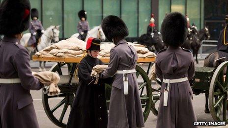 A member of the Household Cavalry Mounted Regiment receives a sandbag of "sacred soil" from First World War battlefields, ahead of the ceremonial procession to transport it to the site of the Flanders Fields memorial garden in Wellington barracks,