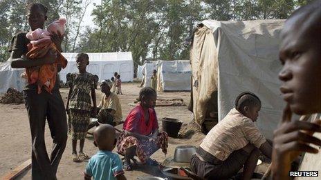 A displaced family sit in front of their tent in the grounds of Saint Antoine de Padoue cathedral in Bossangoa, Central African Republic, November 25, 2013