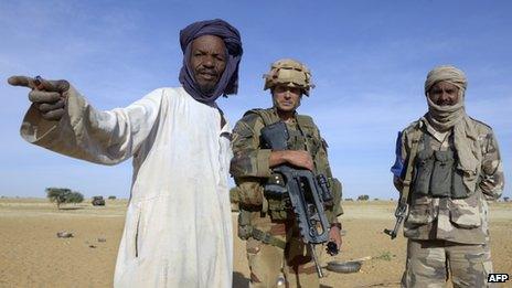 A French soldier and Malian interpreter talk with a nomad near the village of Bamba between Timbuktu and Gao, northern Mali, on October 30, 2013,