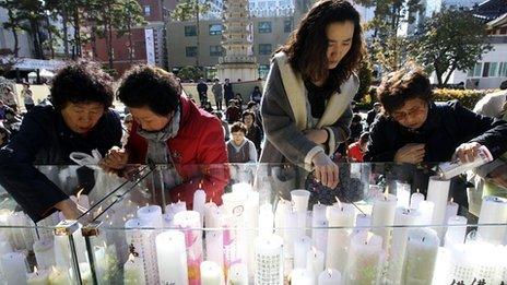 Parents lighting candles for exams