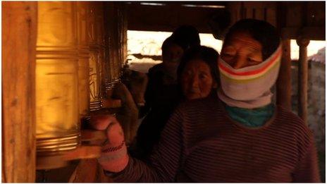 Tibetan women spin prayer wheels