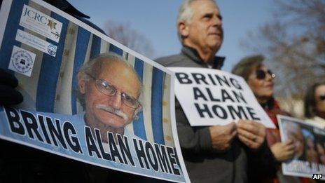 Supporters of Alan Gross, seen on poster at left, hold an event to mark his fourth year in prison in Cuba, 3 December 2013