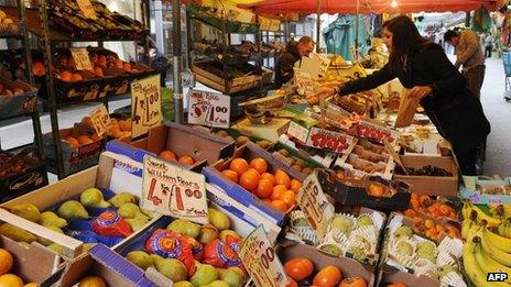 A woman buys fruit at a stall