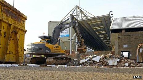 A digger works to demolish the stand