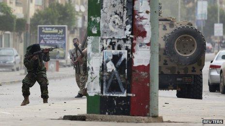 A member of the Libyan army shoots towards members of Islamist militant group Ansar al-Sharia during clashes between the group and a Libyan army special forces unit in the Ras Obeida area in Benghazi November 25, 2013