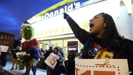 A woman protests wages outside a McDonalds in Chicago, Illinois on 5 December 2013