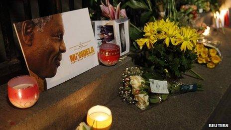 Flowers, candles and tributes are left in memory of Nelson Mandela outside the South African High Commission in London