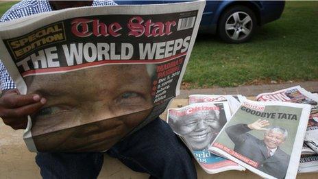 A man reads, in Soweto on December 6, 2013, a local newspaper, The Star, with the front page dedicated to South African former President Nelson Mandela, following his death in Johannesburg on the eve