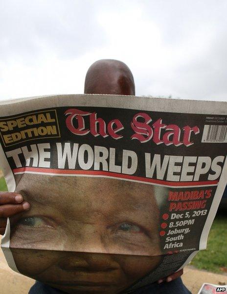 A man reads The Star in Soweto, South Africa, 6 December