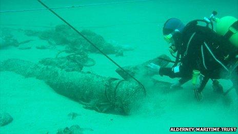 Diver examining cannon on Alderney Elizabethan wreck on seabed