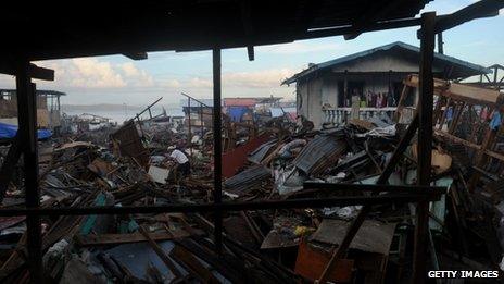 A man search for salavageable materials among debris of destroyed houses in Tacloban, Leyte province on December 6