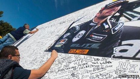 Fans sign a giant poster of Paul Walker at his Fan Memorial on December 8, 2013 in Valencia, California.