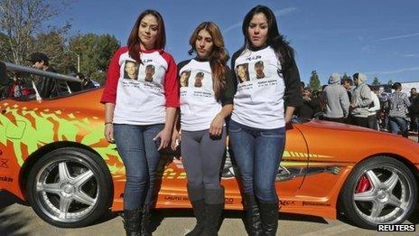 Fans wear shirts commemorating Fast & Furious star Paul Walker and Roger Rodas during an unofficial memorial event in Santa Clarita, California