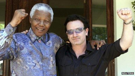 Former South African President Nelson Mandela (L) and Irish rock star Bono pose together after meeting at Mandela's residence at Houghton in Johannesburg, in this May 25, 2002 file photo