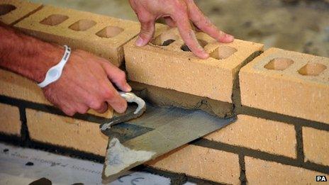 A close-up of a brick-layer's hands