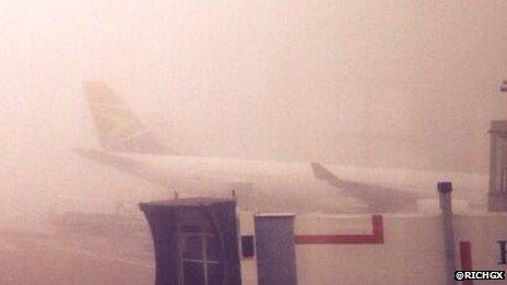 A plane seen through the fog at Heathrow