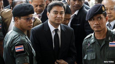 Democrat Party leader and former prime minister Abhisit Vejjajiva (centre) arrives at Bangkok criminal court in Bangkok, 12 December 2013