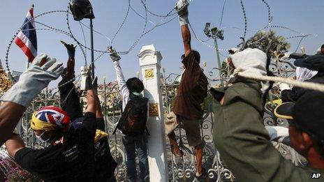 Thai anti-government protesters remove barbed wire erected by Thai police on the fence of Prime Minister's office known as Government House in Bangkok, Thailand 12 December 2013