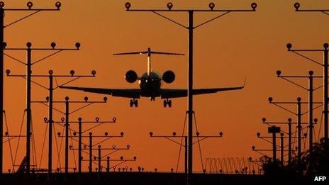 A plane comes in for a landing at Los Angeles International Airport (LAX) at dusk 1 November 2013