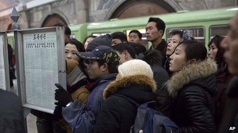 Metro commuters in Pyongyang read public newspaper