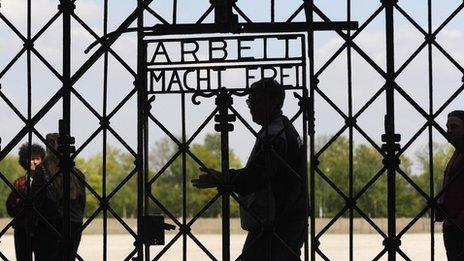 Visitors walk past a gate with 'Work makes you Free' written on it at the memorial site of the former Nazi concentration camp in Dachau, file image