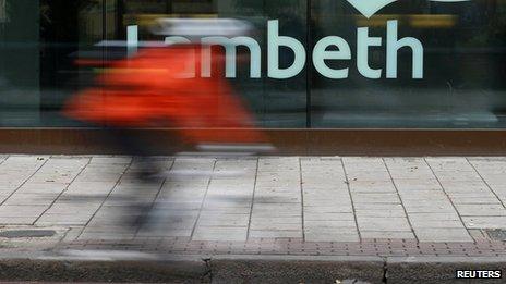 A cyclist passes a Lambeth sign on a council building in south London