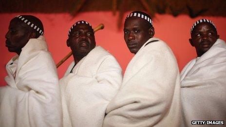 Xhosa men gather in an elder's home before slaughtering a cow as part of a a ceremony in Qunu, ahead of the funeral of Nelson Mandela