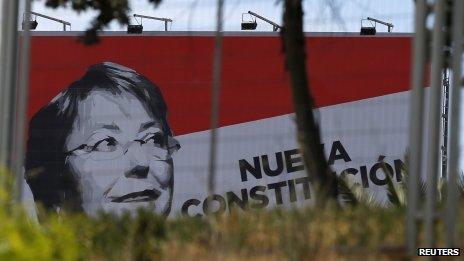 A sign with an image of of Michelle Bachelet is seen next to a road in Santiago on 3 December, 2013