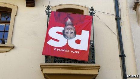 An image of Michelle Bachelet hangs upside down as student protesters take part in an occupation of the Chilean socialist party headquarters in Santiago on 14 August, 2013