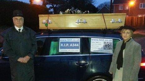 Campaigners against traffic levels on the A303 in Wiltshire drive a coffin mounted on a car