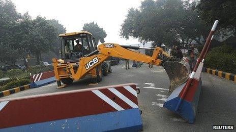 A bulldozer removes the security barriers in front of the U.S. embassy in New Delhi 17 December 2013