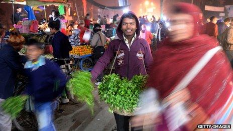 Market in India with man holding herbs