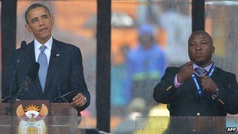 US President Barack Obama delivers a speech at the Nelson Mandela memorial next to sign language interpreter Thamsanqa Jantjie