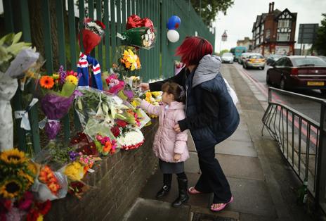 Woman and child leave floral tribute to Lee Rigby at the murder scene