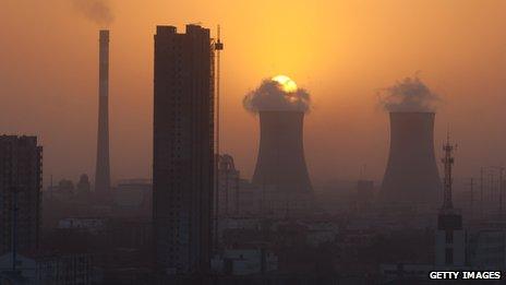 The sun sets behind chimneys in the city of Baoding, Hebei, 140 km south of Beijing