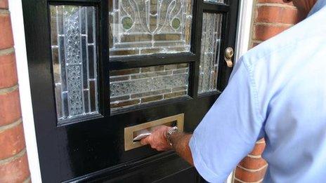 Postman putting letters through a letter box