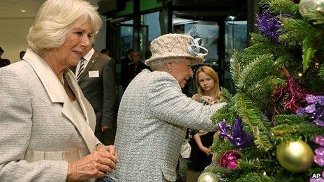 The Queen and Duchess of Cornwall hang decorations on a Christmas tree